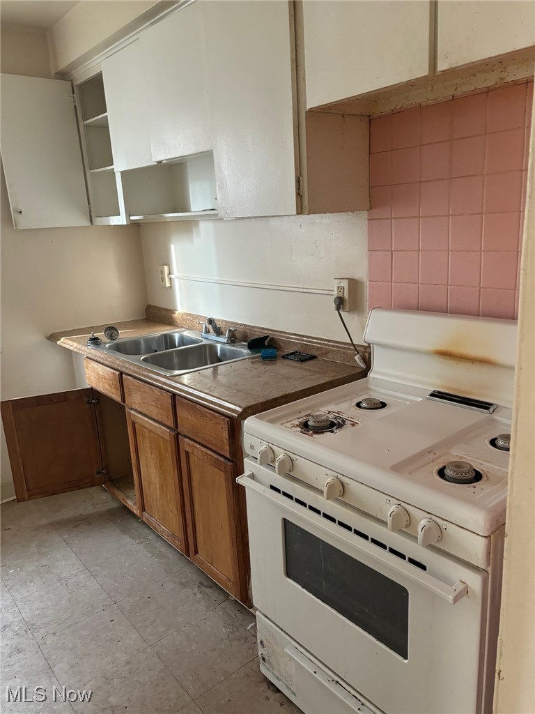 1514 Coventry Road Cleveland, OH 44118 - Photo 24 of 27 Kitchen featuring white range oven, backsplash, and sink