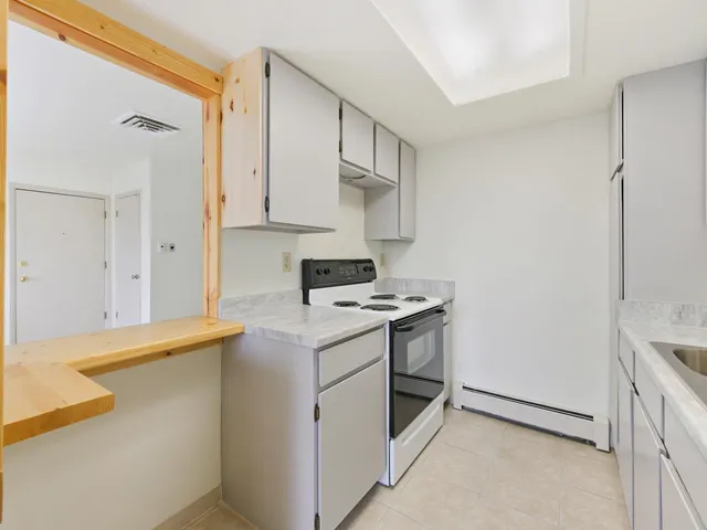 a kitchen with stainless steel appliances a stove a refrigerator and cabinets