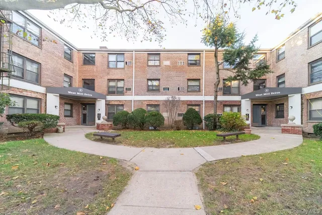 a front view of a building with garden and porch