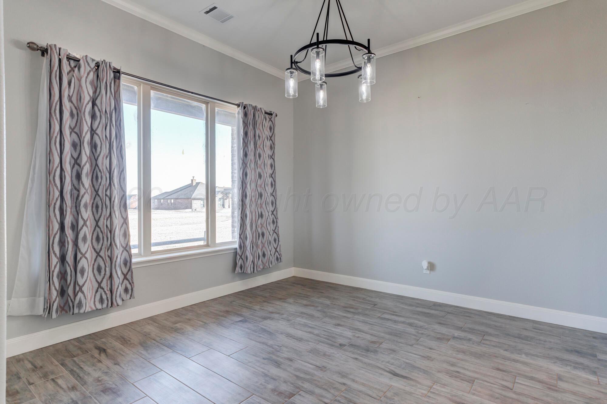 14310 Lobelia Place Amarillo, TX 79119 - Photo 21 of 78 a view of an empty room with wooden floor and a window