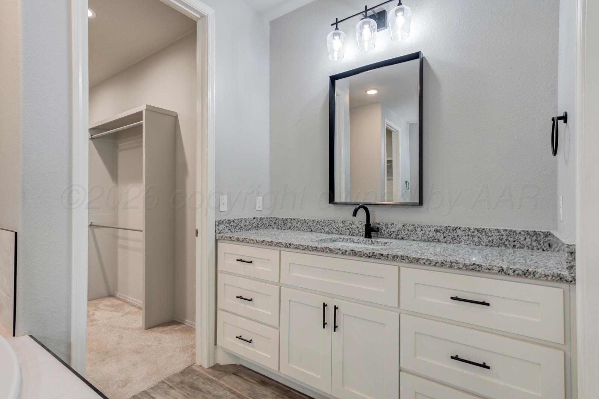 14310 Lobelia Place Amarillo, TX 79119 - Photo 29 of 78 a bathroom with a granite countertop sink and a mirror