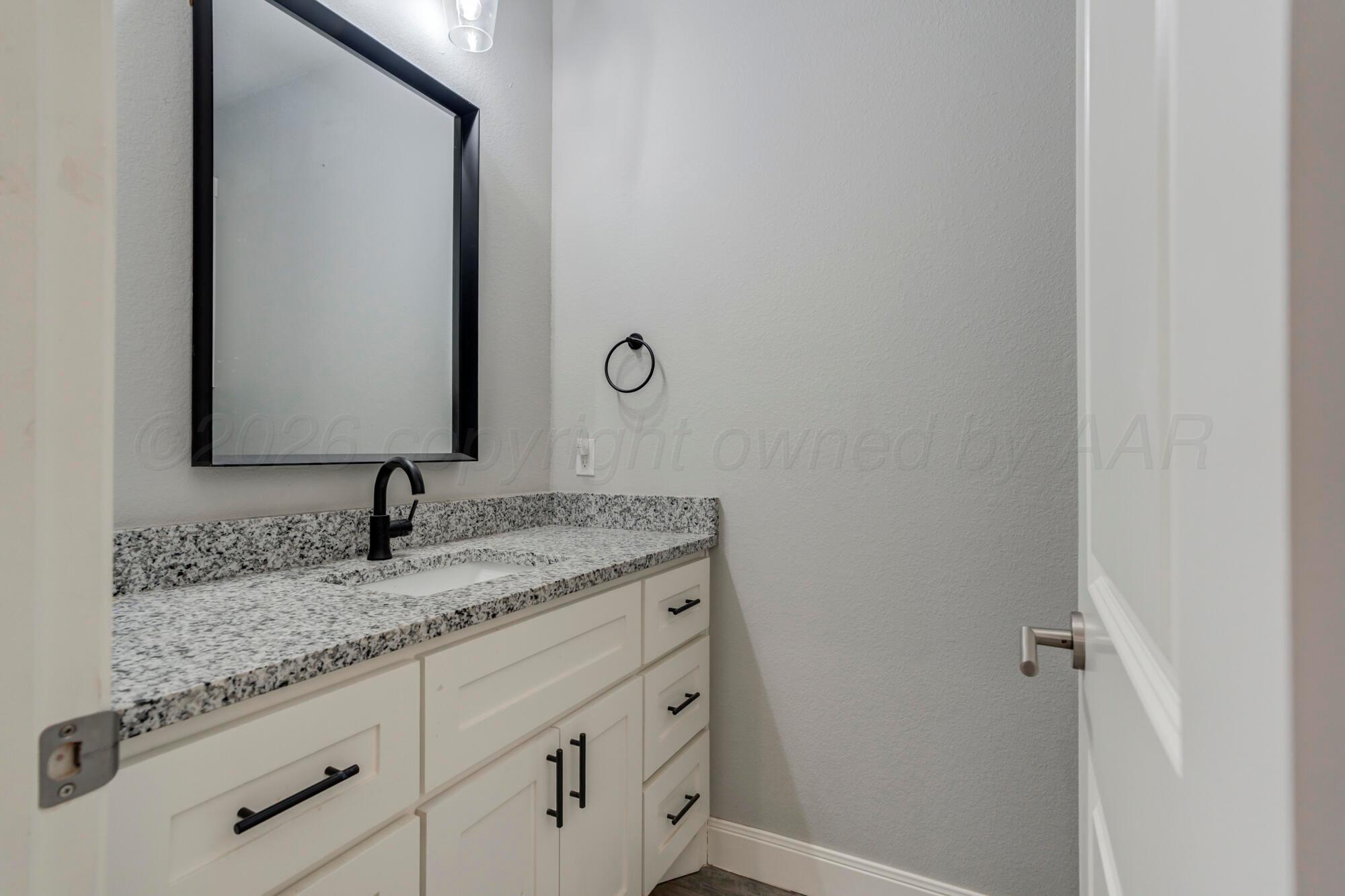 14310 Lobelia Place Amarillo, TX 79119 - Photo 43 of 78 a bathroom with a granite countertop sink and a mirror