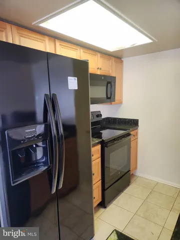 a kitchen with stainless steel appliances granite countertop a refrigerator and a stove