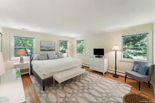a bedroom with a bed and large windows