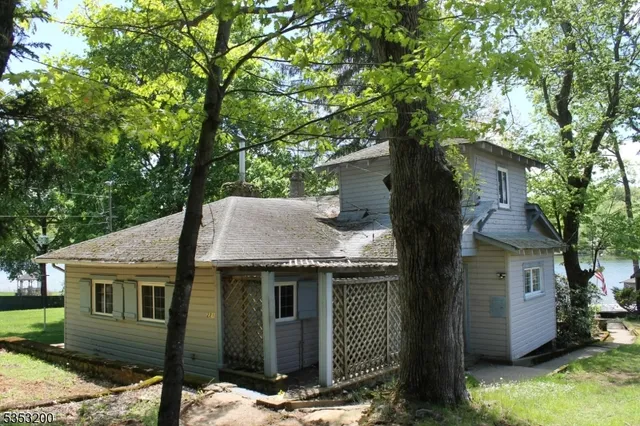a front view of a house with yard tree and wooden fence
