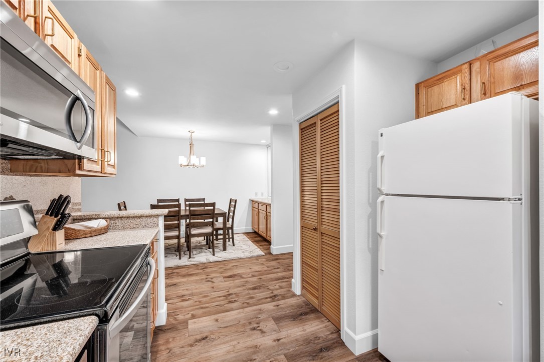 931 Incline Way, Unit 231 Incline Village, NV 89451 - Photo 31 of 39 a kitchen with a refrigerator a stove a sink and a dining table with wooden floor