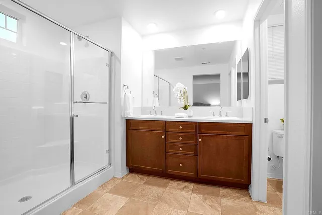 a bathroom with a granite countertop sink mirror and shower