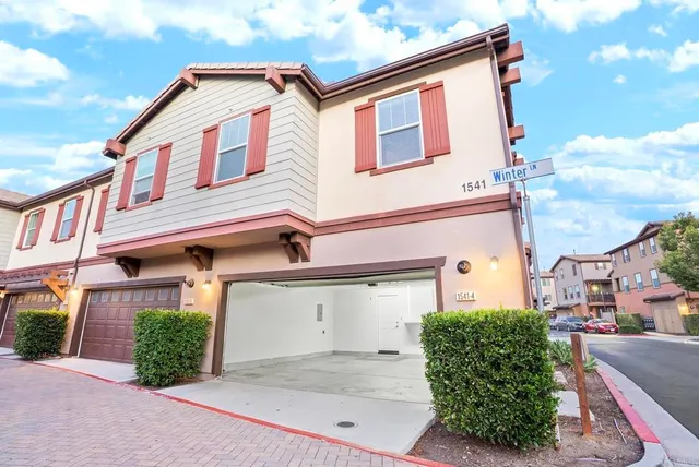 a view of a street with plants and large trees