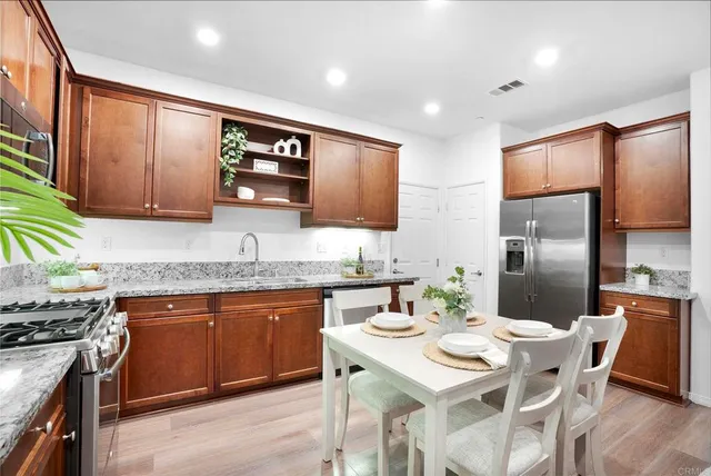 a kitchen with granite countertop a sink stove and refrigerator