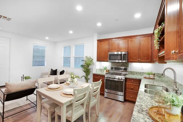 a kitchen with stainless steel appliances granite countertop a stove a sink and a refrigerator