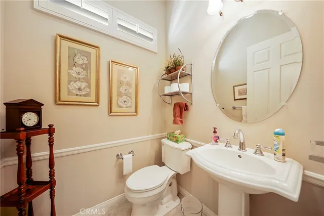 a bathroom with a toilet a sink and a mirror