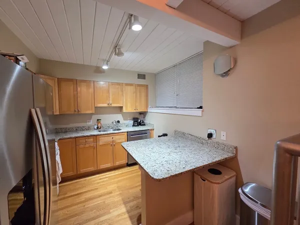 a kitchen with granite countertop a sink stove and refrigerator