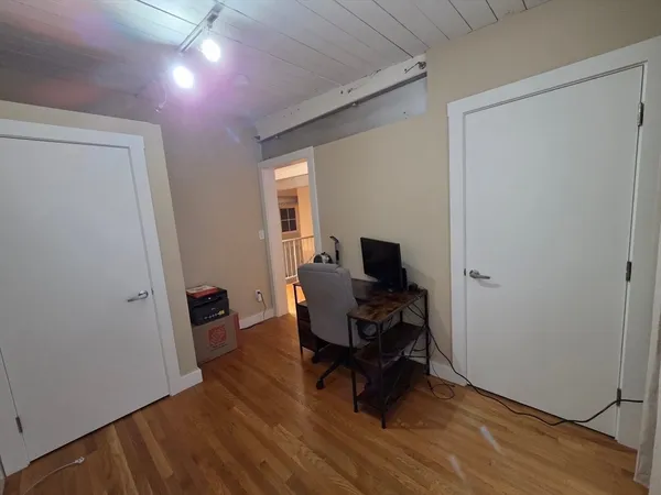 a view of a workspace with furniture and a window