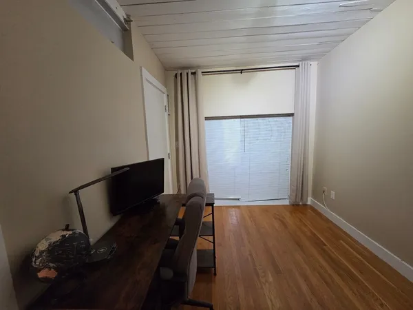 a view of a room with wooden floor and a window