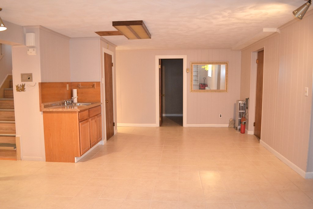 328 Angell Road Lincoln, RI 02865 - Photo 31 of 38 Finished basement showing sink, storage room, and the door at right into the garage