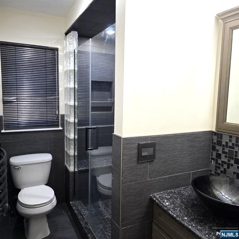24 Van Vechten Street, Unit 2 Newark, NJ 07114 - Photo 14 of 36 a bathroom with a granite countertop toilet and a sink