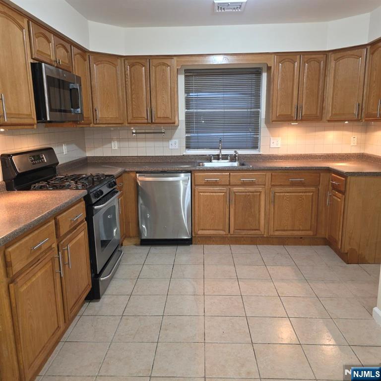 24 Van Vechten Street, Unit 2 Newark, NJ 07114 - Photo 5 of 36 a kitchen with stainless steel appliances granite countertop a stove a sink and a microwave