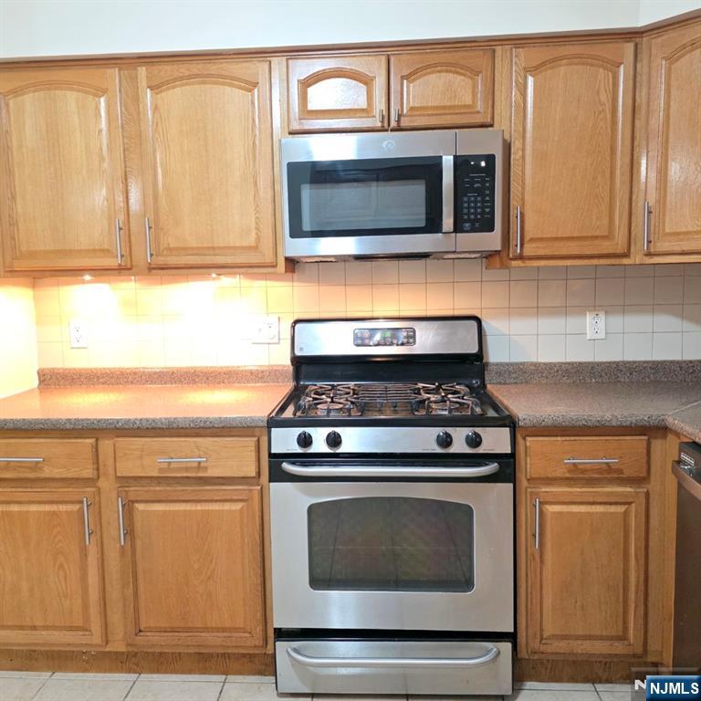 24 Van Vechten Street, Unit 2 Newark, NJ 07114 - Photo 6 of 36 a kitchen with granite countertop a stove microwave and oven