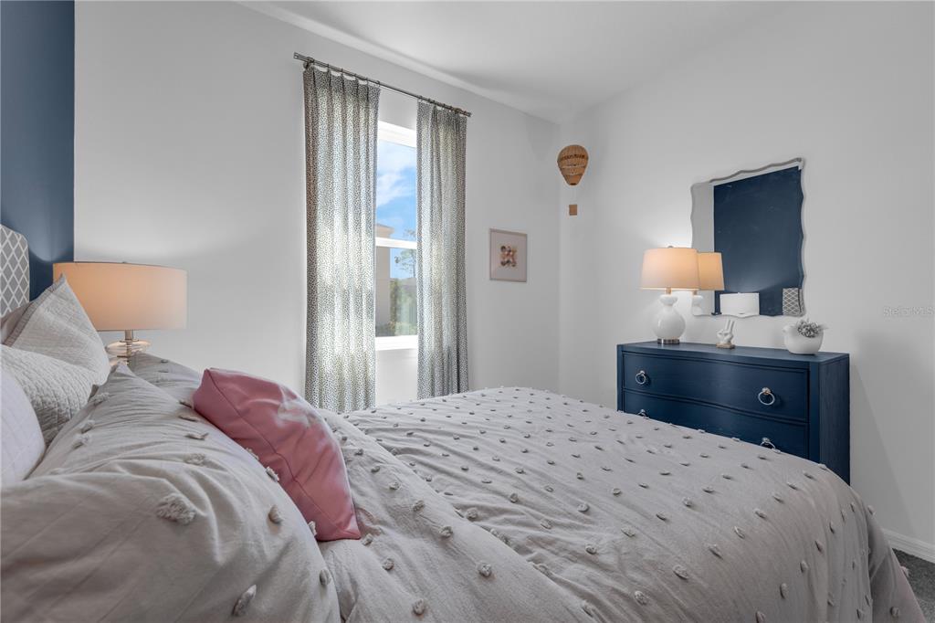 1267 Blue Daze Lane Eustis, FL 32726 - Photo 21 of 34 a bedroom with a bed and a lamp on dresser