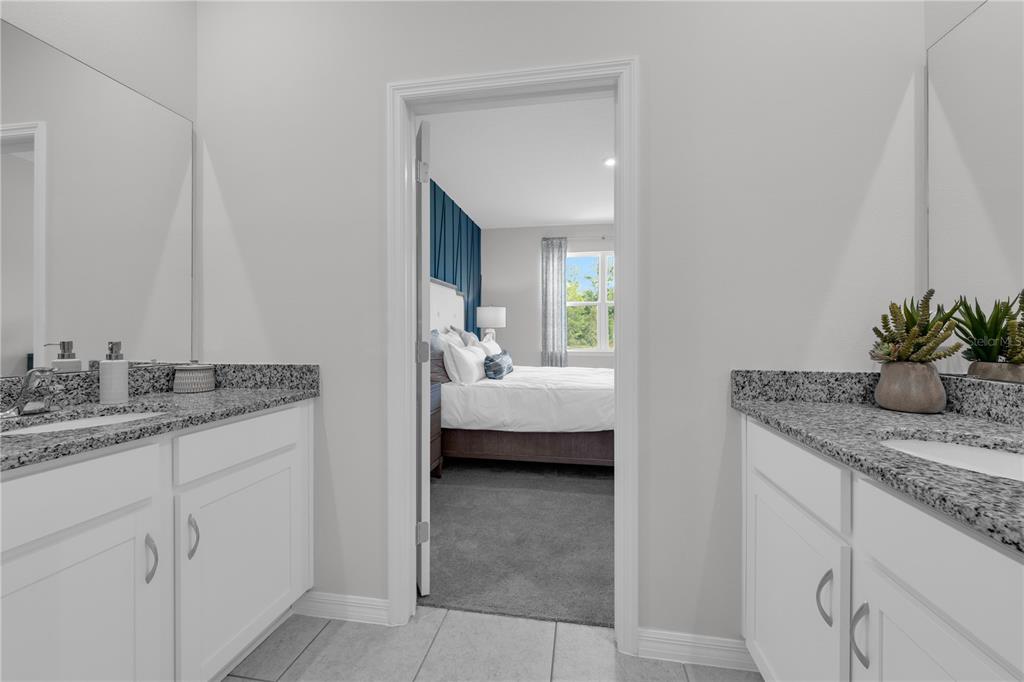 1267 Blue Daze Lane Eustis, FL 32726 - Photo 33 of 34 a en suite bathroom with a granite countertop sink and a mirror