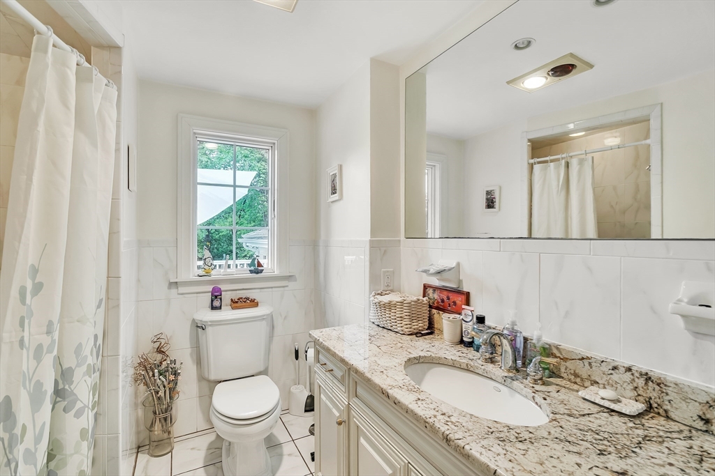 10 Ballard Terrace Lexington, MA 02420 - Photo 24 of 42 a bathroom with a granite countertop sink toilet and mirror