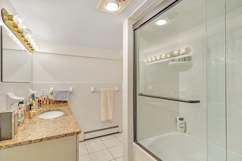 10 Ballard Terrace Lexington, MA 02420 - Photo 35 of 42 a bathroom with a granite countertop sink a mirror and shower