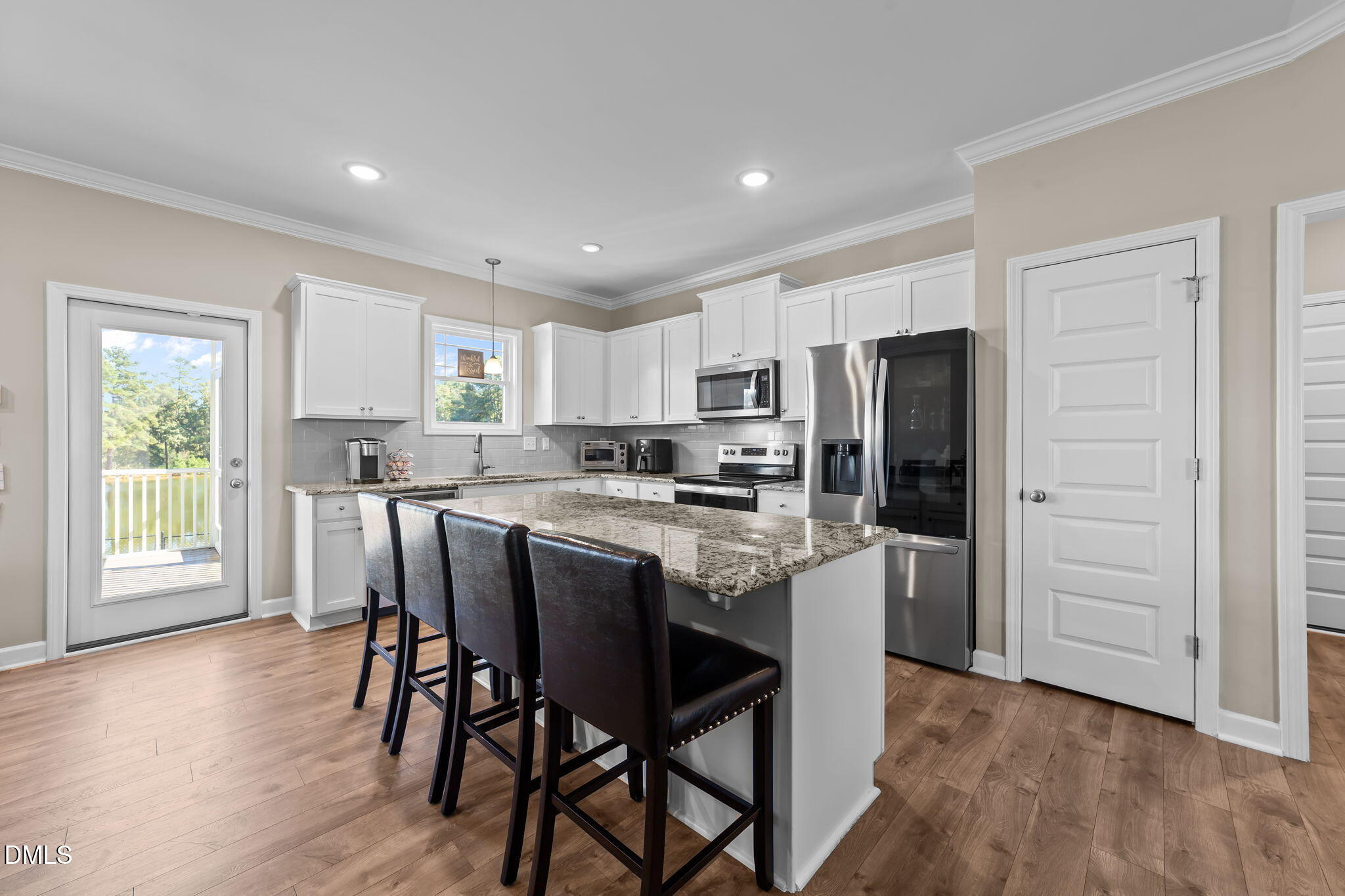 73 Rabbit Run Drive Smithfield, NC 27577 - Photo 12 of 46 a kitchen with stainless steel appliances granite countertop a refrigerator a microwave oven a sink with island and chairs with wooden floor