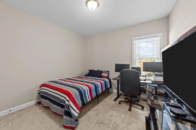 a bedroom with bed and tv on desk