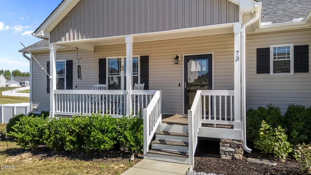 a view of a balcony with chairs and wooden floor