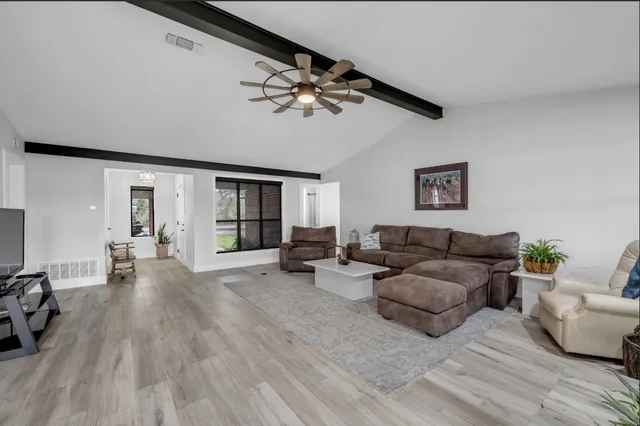a living room with furniture and a wooden floor
