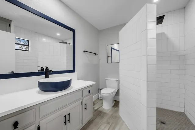 a bathroom with a sink a toilet and a mirror