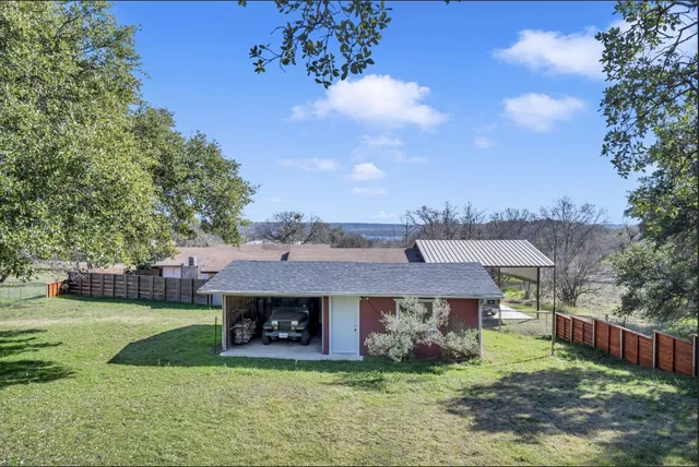 a view of a big house with a big yard and large tree