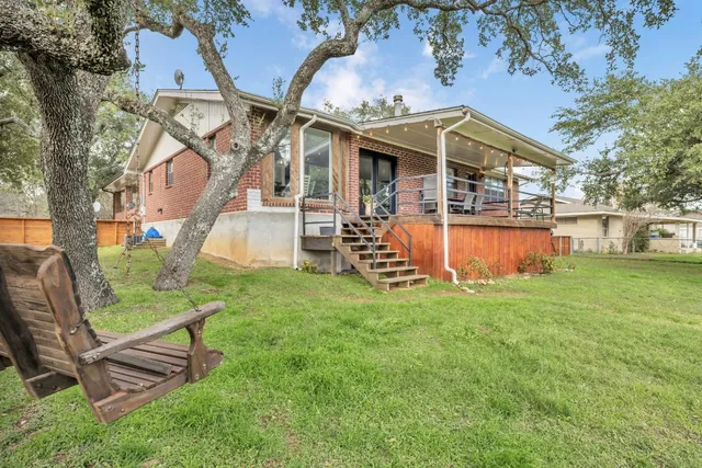 an aerial view of a house with backyard and wooden fence