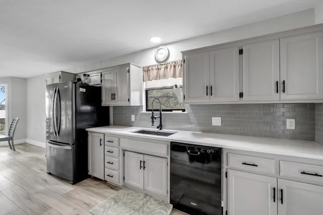 a kitchen with a sink dishwasher a refrigerator and cabinets
