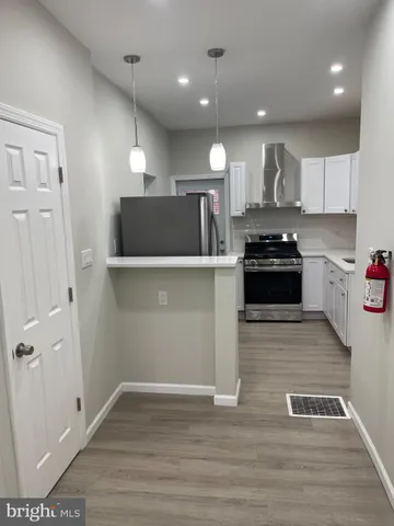 a kitchen with kitchen island a counter top space cabinets and stainless steel appliances