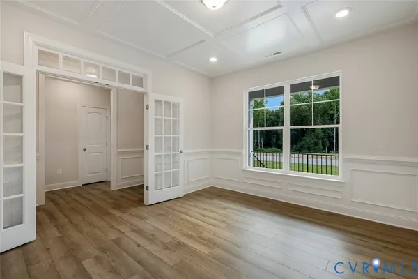 an empty room with wooden floor and windows