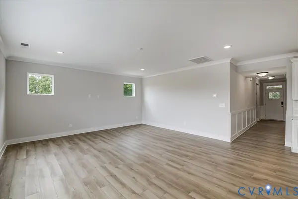 a view of an empty room with wooden floor