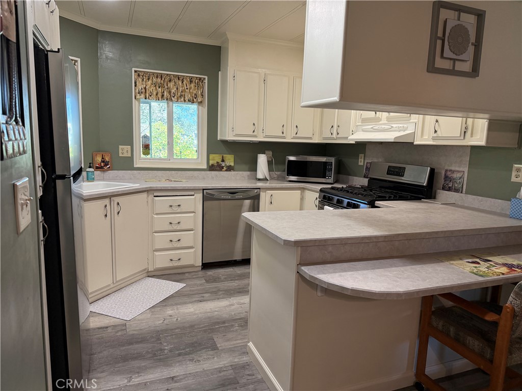 7452-7452 Live Oak Road Corning, CA 96021 - Photo 10 of 19 a kitchen with stainless steel appliances granite countertop a sink stove and refrigerator