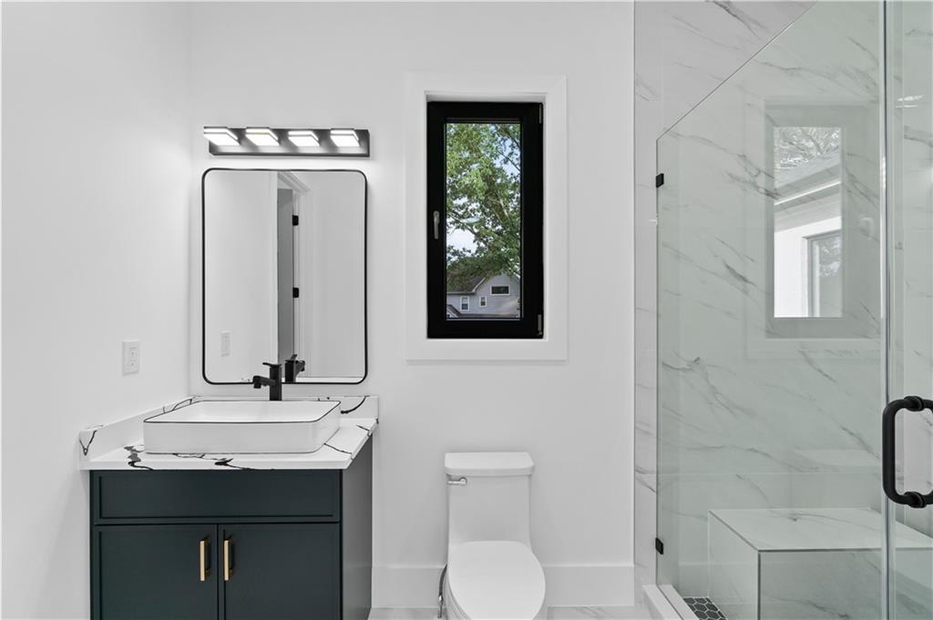 2709 Collins Hill Road Lawrenceville, GA 30043 - Photo 37 of 67 a bathroom with a toilet a sink a mirror and a window