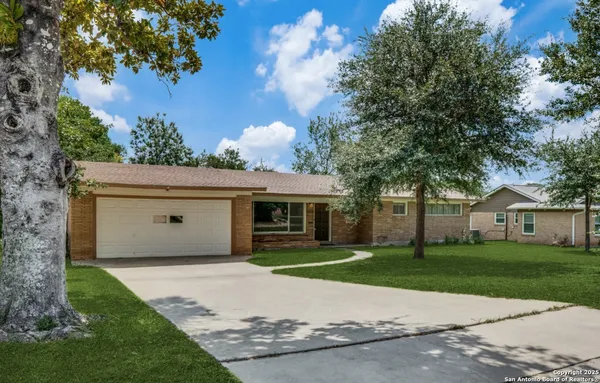 a front view of house with yard and trees around