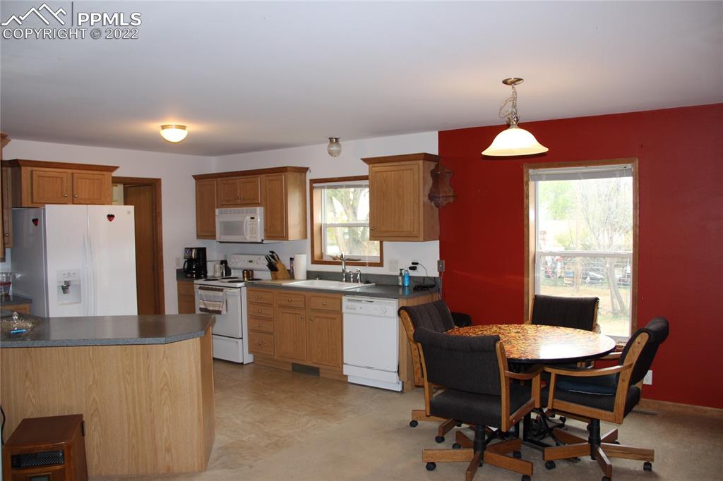 749 9th Street Calhan, CO 80808 - Photo 8 of 43 a kitchen with a dining table chairs and refrigerator
