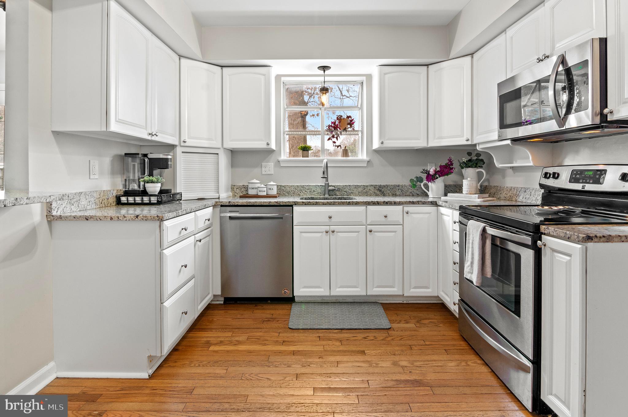 40 Dorba Court Severna Park, MD 21146 - Photo 11 of 67 a kitchen with stainless steel appliances granite countertop a stove top oven a sink dishwasher and white cabinets with wooden floor