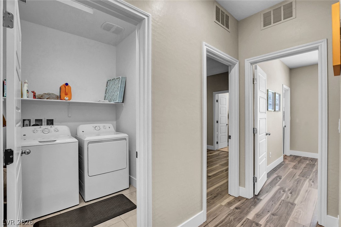 9688 Rankin Rdg Court Las Vegas, NV 89178 - Photo 24 of 53 Functional laundry space with storage and appliances, conveniently positioned in a central hallway with wood flooring.
