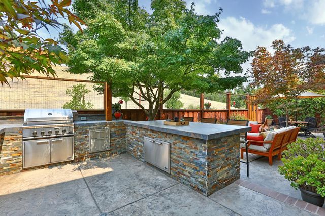 a view of a patio with couches and table under an umbrella