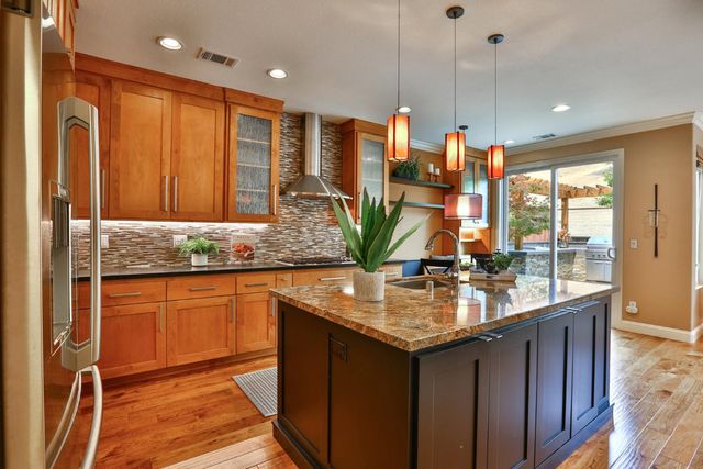 a kitchen with stainless steel appliances granite countertop sink stove and refrigerator
