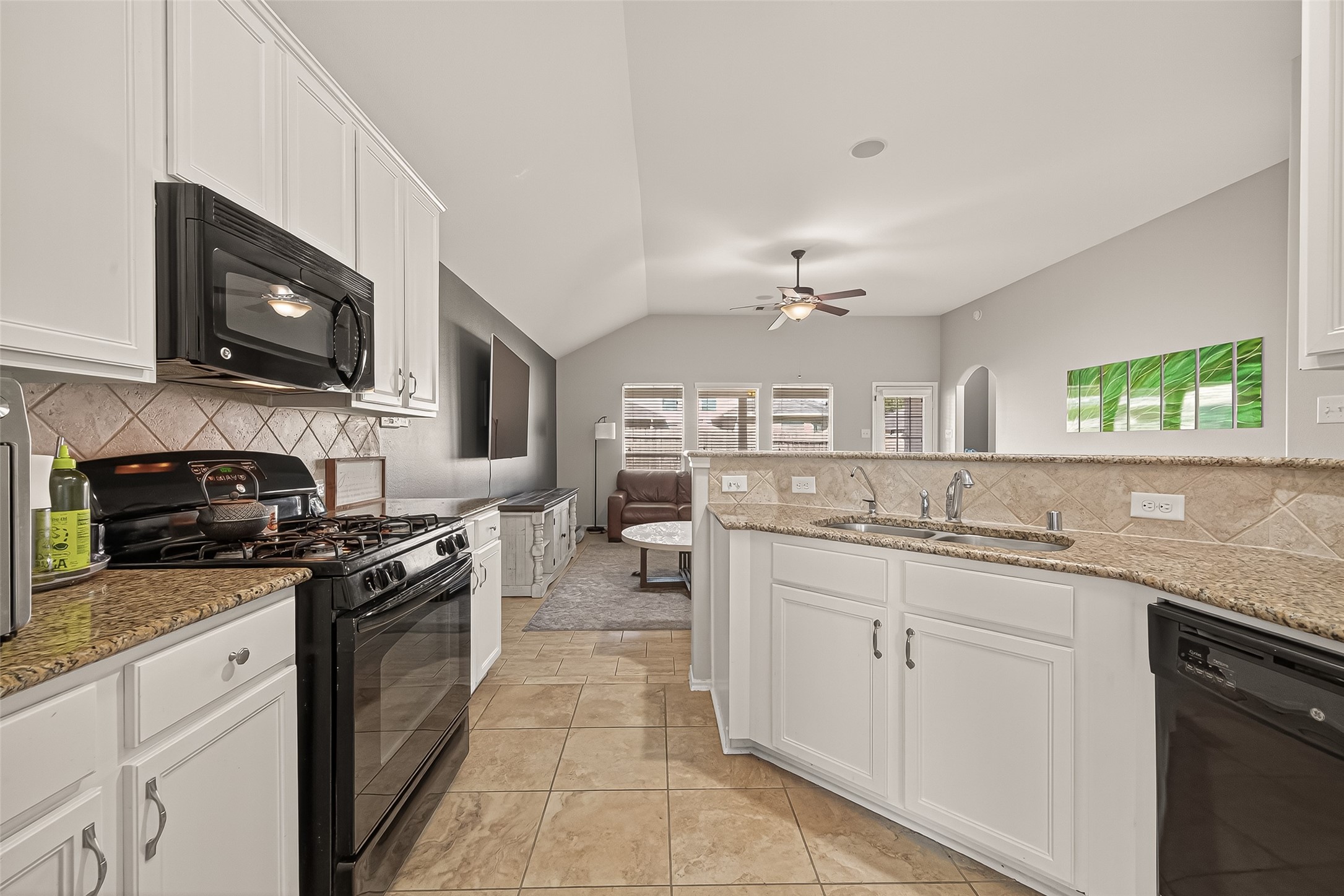 15607 Mossy Park Cypress, TX 77429 - Photo 12 of 34 a kitchen with stainless steel appliances granite countertop a stove top oven a sink dishwasher and a microwave oven with white cabinets