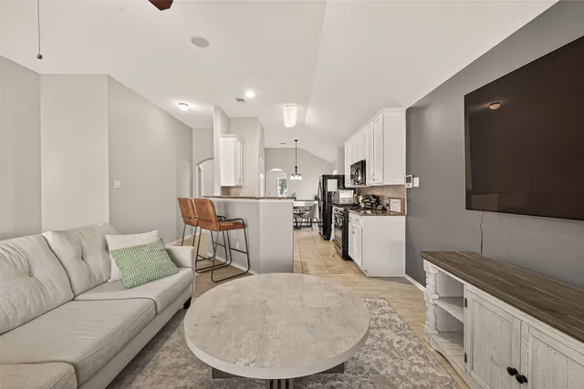 a living room with furniture and kitchen view