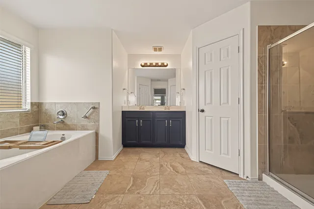 a spacious bathroom with a bathtub sink and mirror
