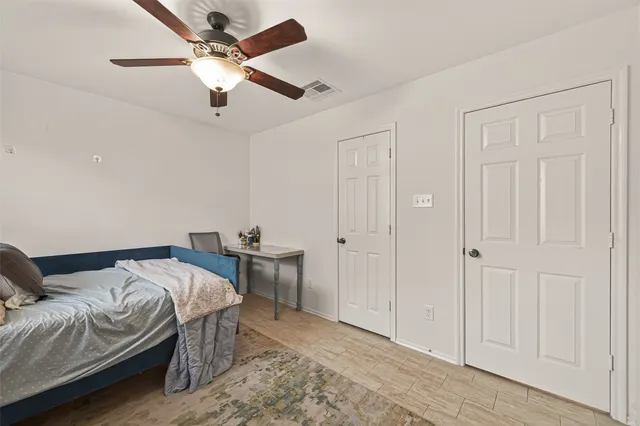 a bedroom with a bed and a ceiling fan
