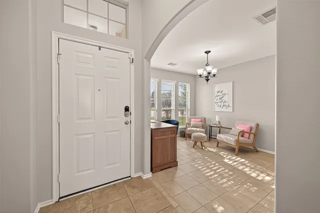 a living room with furniture and a chandelier